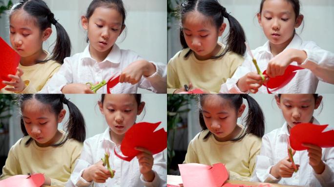 两名认真玩剪纸游戏的中国女孩