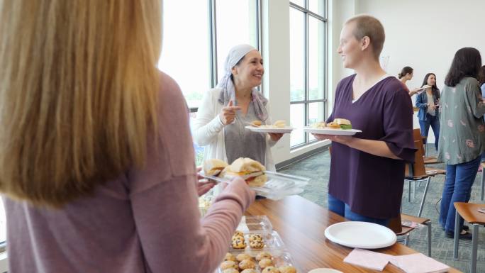 女性在乳腺癌支持小组会议前吃甜点