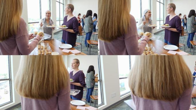 女性在乳腺癌支持小组会议前吃甜点