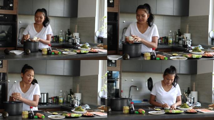 一名泰国女子，一名寿司厨师，将寿司米饭放在海苔上，准备传统寿司卷作为午餐
