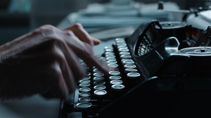 一个在旧打字机上快速工作的女人