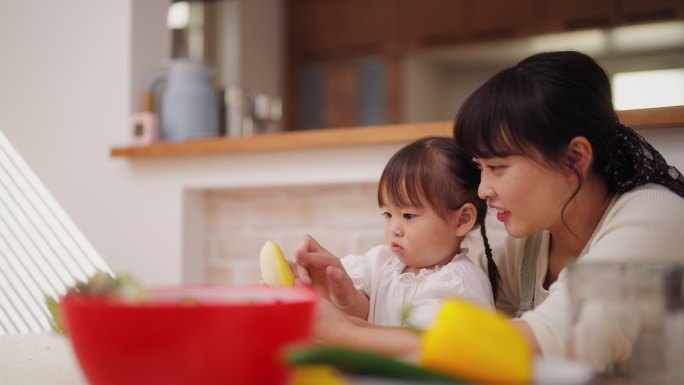 母亲帮助她的小女儿做冰沙，鼓励她健康饮食