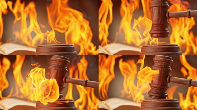 SLO MO LD木槌在桌子上敲击燃烧的声音块，背景是一本正在燃烧的书