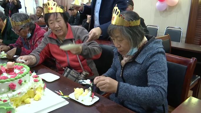 重阳节社区集体给老人过生日吃蛋糕吹蜡烛