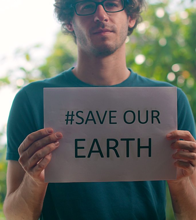 男子手持拯救地球标志的垂直视频。