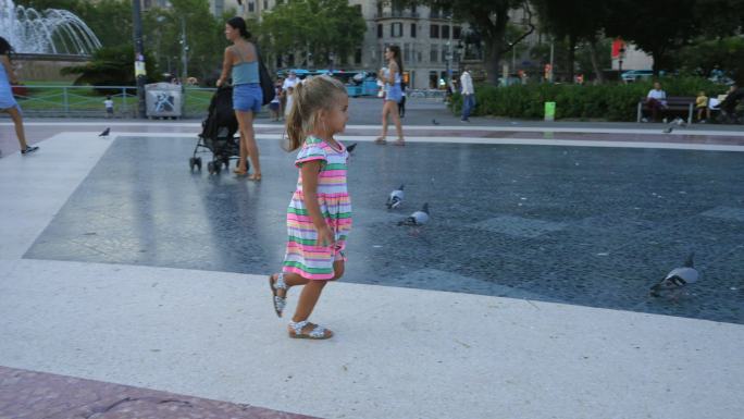 巴塞罗那加泰罗尼亚解放军上追逐鸽子的小女孩