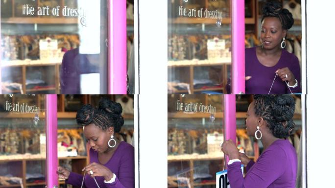 黑人妇女在服装店门上挂着“开门”的牌子