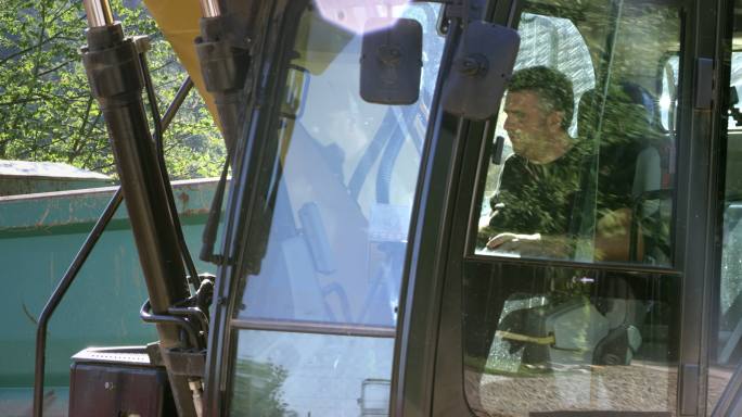 在建筑工地工作的男性挖掘机操作员