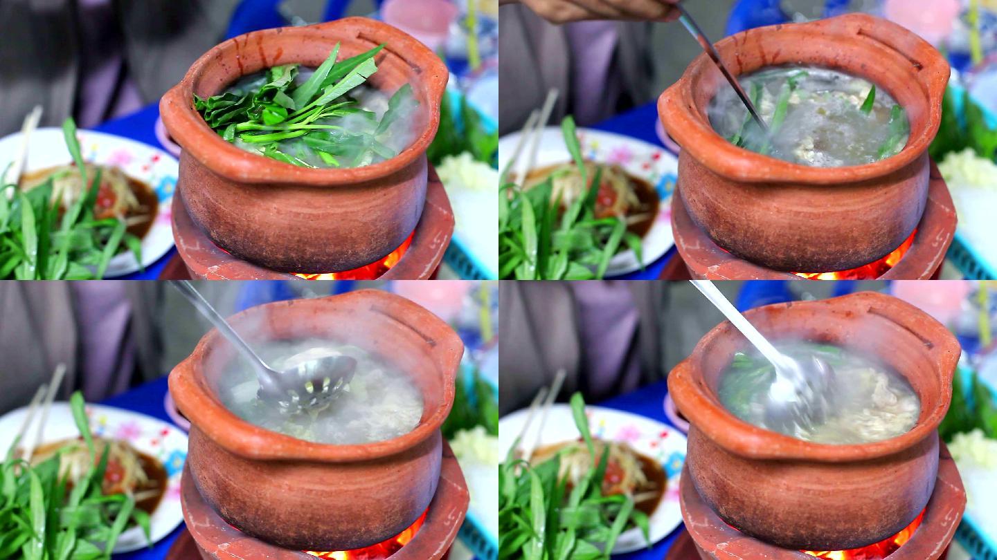 女孩在陶罐里填蔬菜做泰国火锅街头食物（Jim Jum）