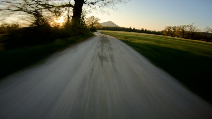 在夕阳下飞驰的乡村公路上