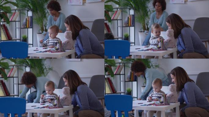 白人母亲在儿科诊所的候诊室与儿子玩耍