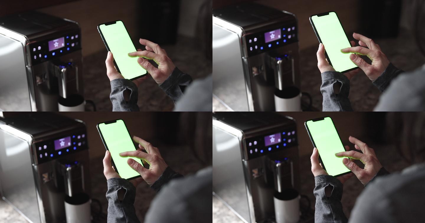 女性手持色度键绿色屏幕智能手机和煮咖啡的特写镜头