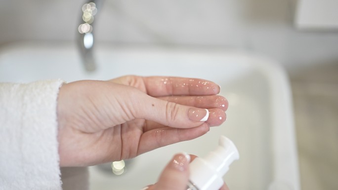 女性沐浴后检查手指上护肤油的粘度