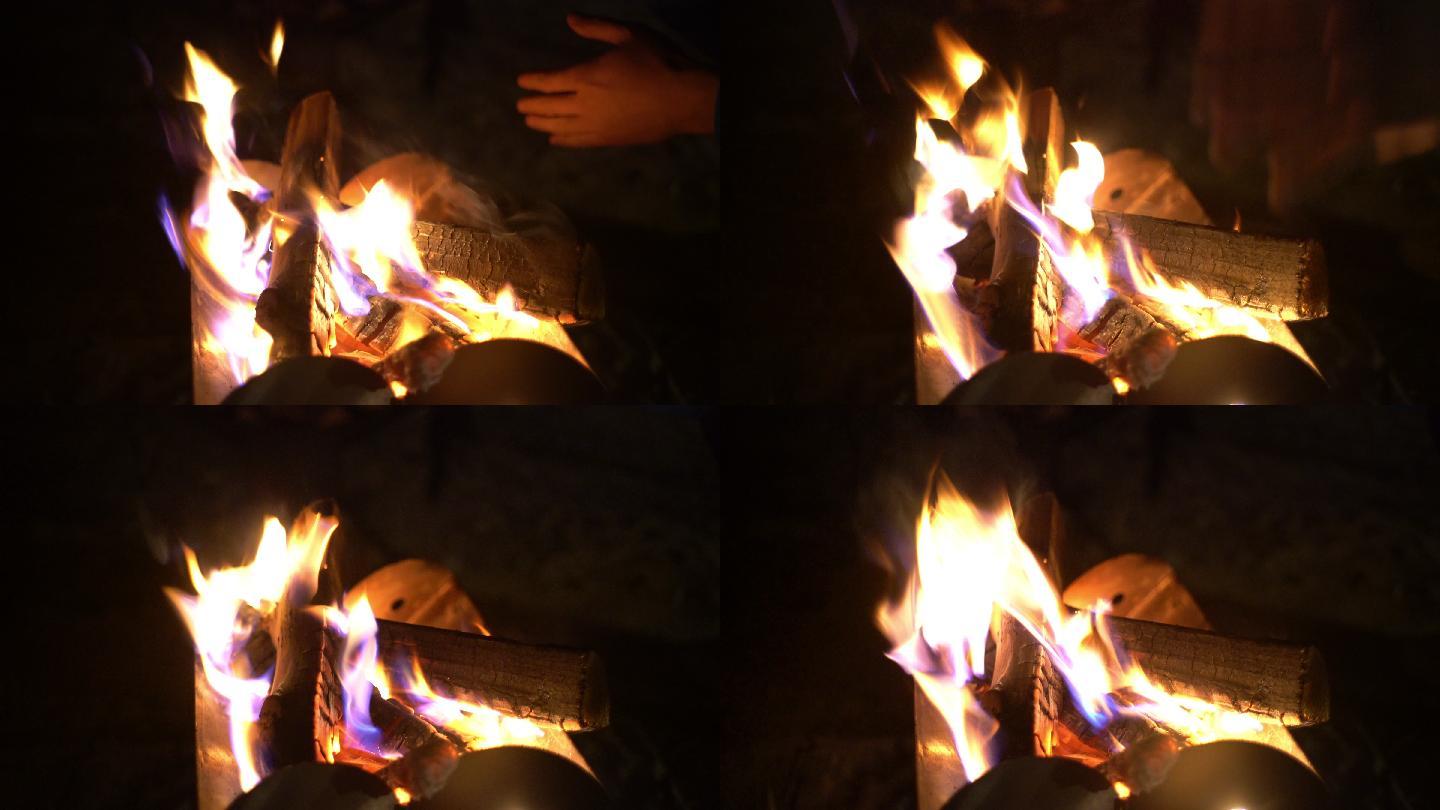 露營地的篝火夜晚烤火冻手寒冷