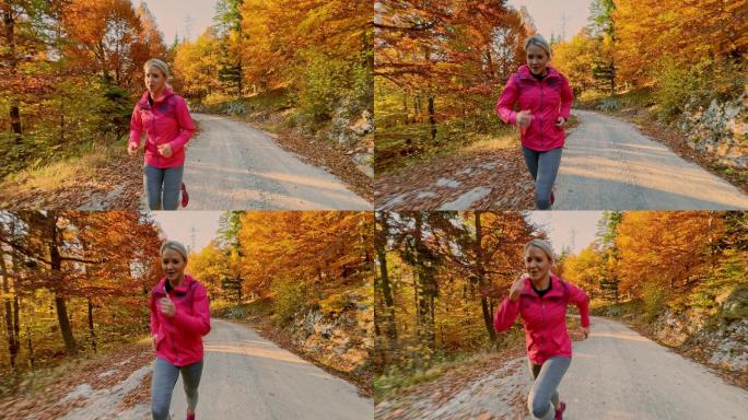 秋天，一名女子跑步运动员在森林公路上疾跑