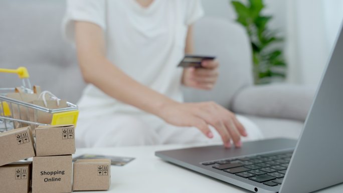 亚洲女性通过信用卡在线支付，并在家里的电脑上购买她们喜欢的东西。概念​​通过电子商务进行网上购物。