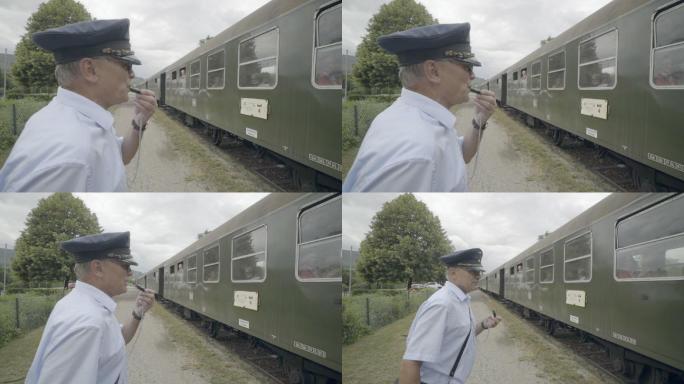 列车长沿着一列旧蒸汽火车走，吹着口哨