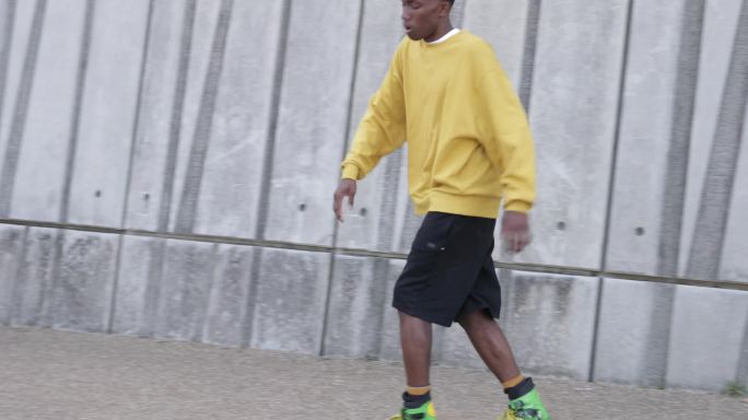 一个年轻人沿着空荡荡的街道溜冰