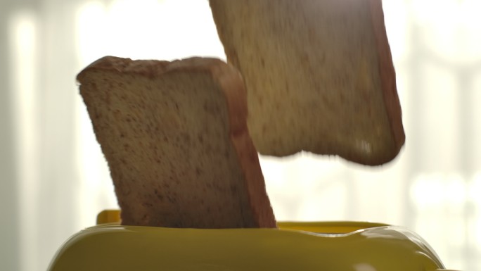 烤面包片以极慢的速度从烤面包机中取出