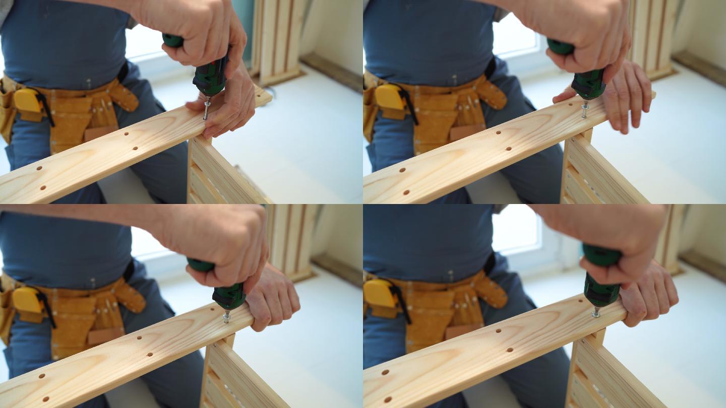 无法辨认的木匠用电动螺丝刀连接厨房家具的特写镜头