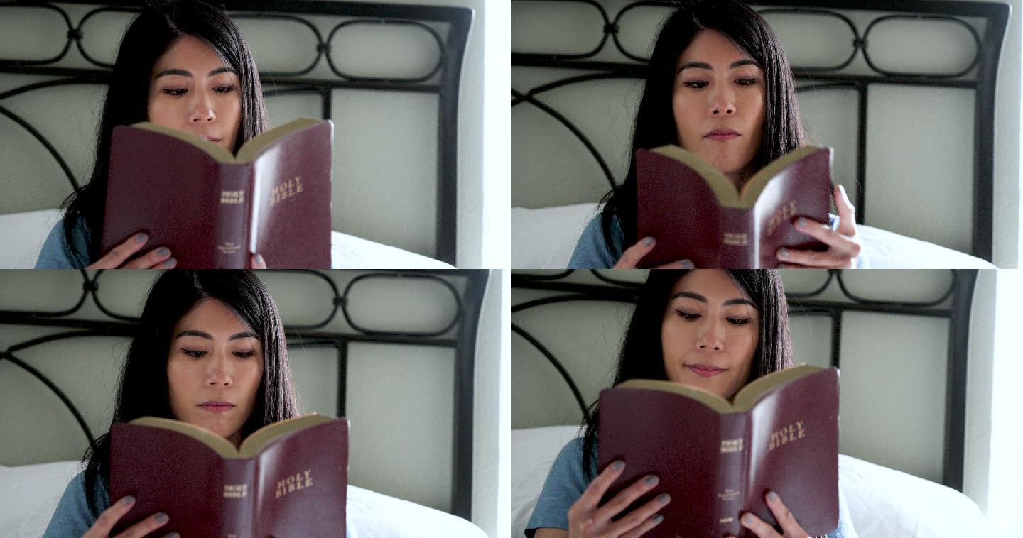 微笑的东亚女人在家读圣经