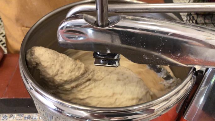 面包架搅拌机在厨房里与面粉一起工作