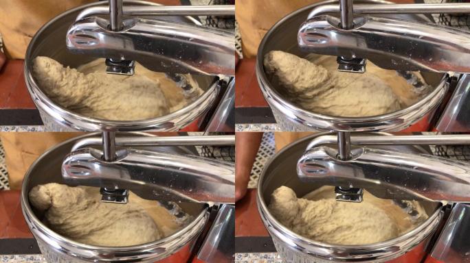 面包架搅拌机在厨房里与面粉一起工作