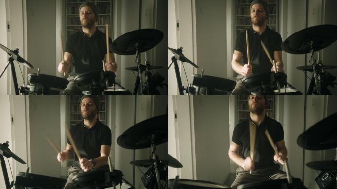 一个男人在客厅里练习电子鼓。前视图