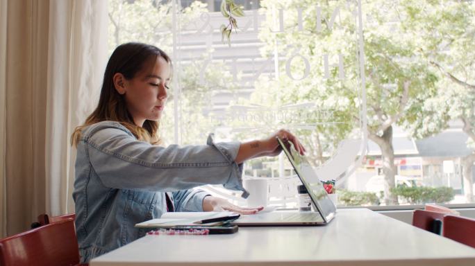 4k视频，一位年轻貌美的女士坐在咖啡馆里使用笔记本电脑