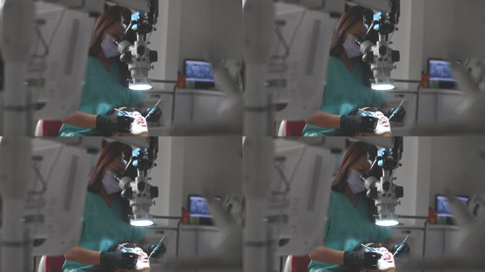 亚裔中国女牙医在牙科诊所通过显微镜观察患者的牙齿
