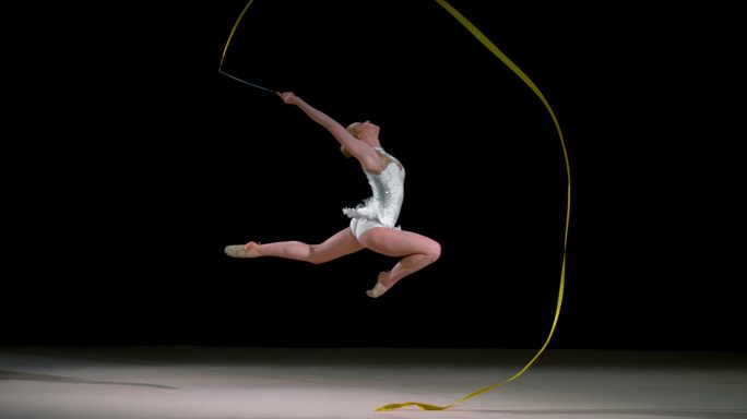 斯洛-莫速度坡道LD艺术体操运动员在空中挥舞着丝带跳跃