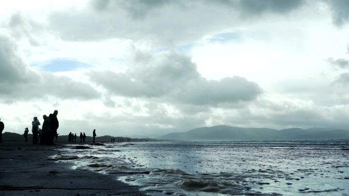 游客们在丁格尔半岛的英寸海滩观看大海