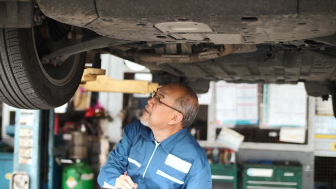 小企业汽车服务所有者在车库检查汽车