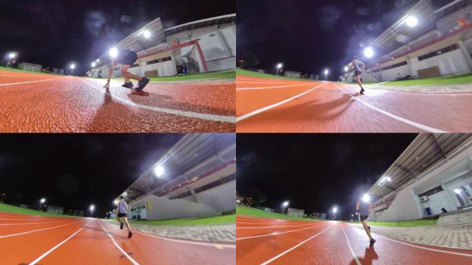 后视图空气动力学亚裔中国男运动员在田径场跑道上冲刺冲向终点线雨夜追踪镜头
