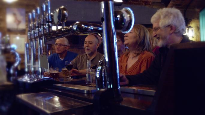 一群五六十岁的朋友在酒吧看足球
