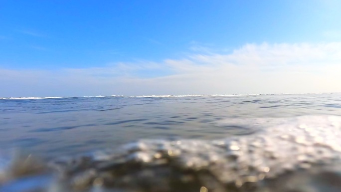 海滩上的浪花。海浪拍打着相机。从低角度拍摄动作摄像机。