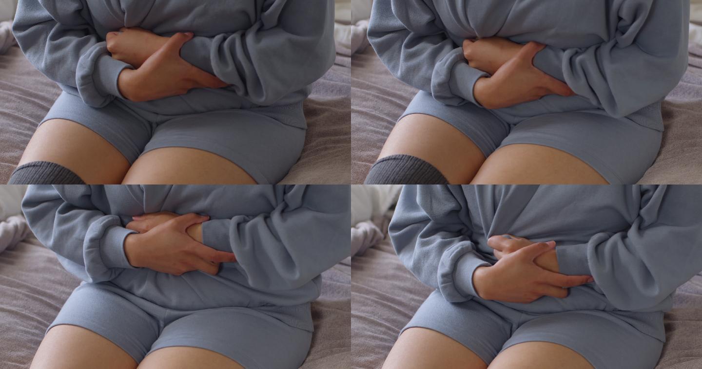 4k视频，一名无法辨认的女子在家躺在床上时胃痛