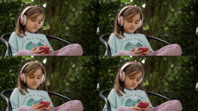 可爱的小女孩戴着耳机听音乐