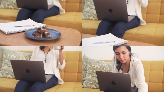 女商人在家用笔记本电脑工作时喝咖啡