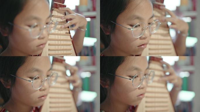 小女孩演奏琵琶（中国琵琶，一种带有磨损指板的拨弦乐器）