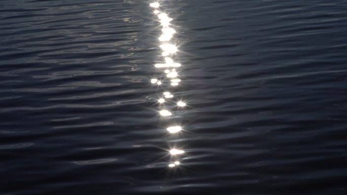 阳光反射在水面上。平静的水面上闪耀着阳光