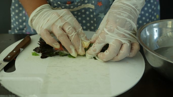 亚洲女性在厨房制作蔬菜沙拉卷，家居行业理念