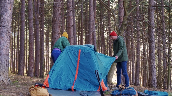 年轻的异性恋情侣搭起帐篷露营