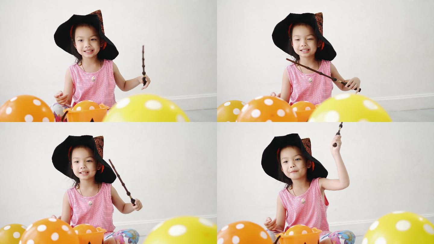亚洲女孩用魔杖和气球，万圣节的概念。