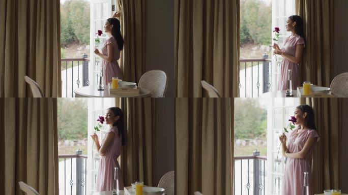4k视频，一位年轻美丽的女子在酒店房间的阳台上欣赏风景