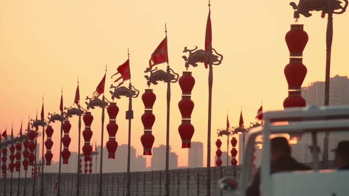 日落时古城墙顶部的龙旗和灯笼/中国陕西西安
