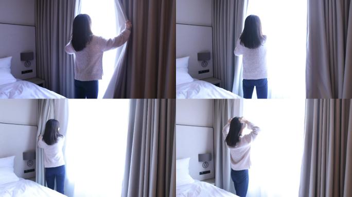 年轻女子在酒店房间拉开窗帘