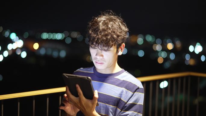 年轻人晚上使用数字平板电脑