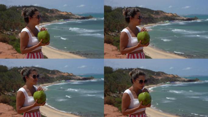 在Praia do Amor喝椰子水的女人