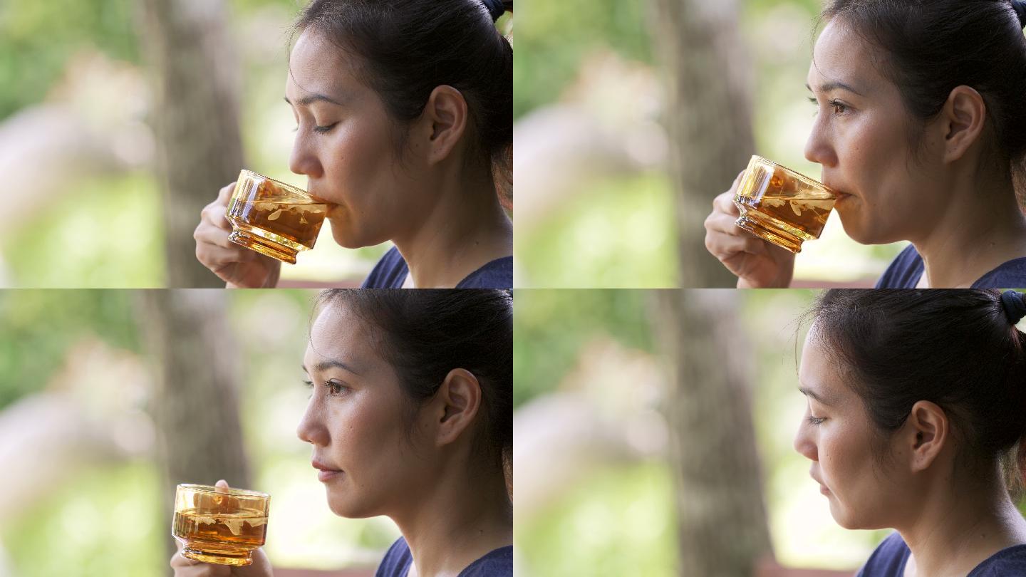 CS 4K亚洲女人喝着热樱花花茶。